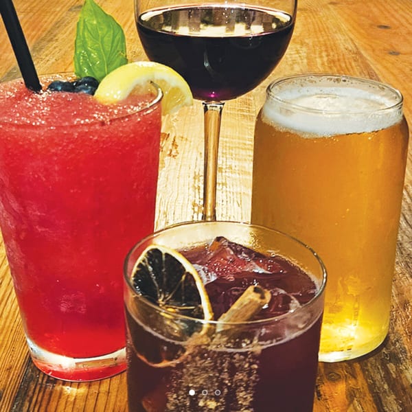 Four Wicked Sisters drinks: a red frozen cocktail, red wine, a beer, and a dark cocktail.